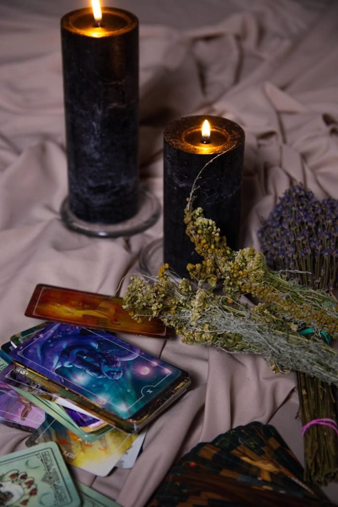 close-up-of-tarot-cards-and-candles-10976275 Intimate setting with tarot cards, candles, and herbs for mystical ambiance.